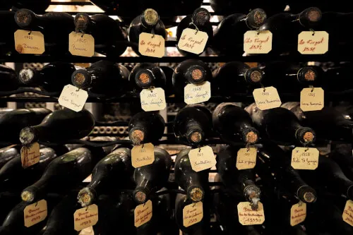 Weinflaschen auf einem Regal im TOP Hotel Hochgurgl, darunter 1865, Clos Vougeot und Vosne Romanée.