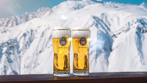 Zwei Biergläser auf einer Ablage mit schneebedeckten Bergen im Hintergrund, Promontoria Hochgurgl GmbH - TOP Hotel Hochgurgl