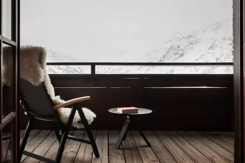 Gemütlicher Balkon mit einem Fellsessel und Blick auf die verschneiten Berge im TOP Hotel Hochgurgl.