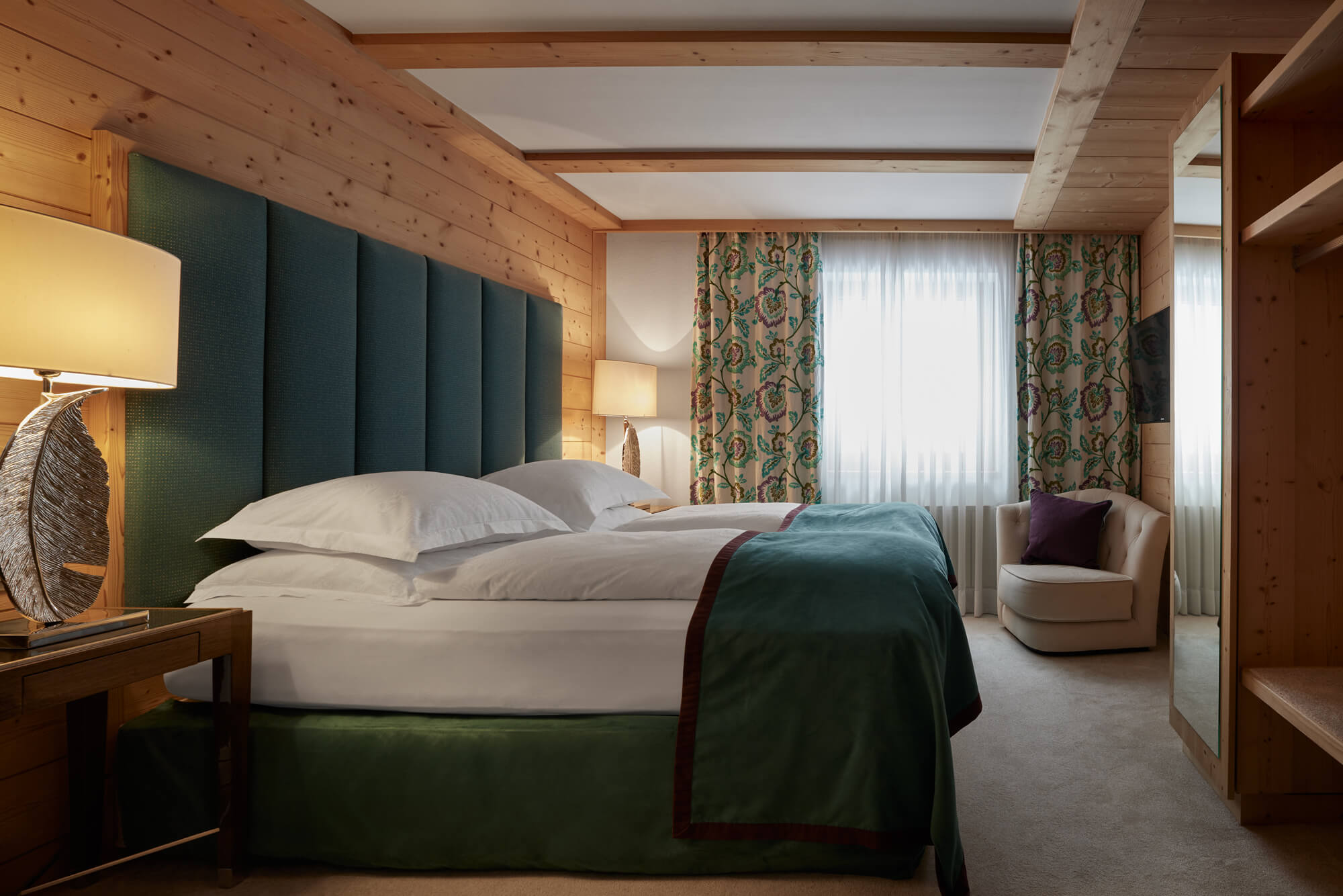 Ein Zimmer mit einem Bett und einem Stuhl im TOP Hotel Hochgurgl