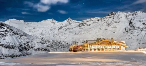 Gemütliches Berghaus in Hochgurgl, umgeben von verschneiten Bergen.