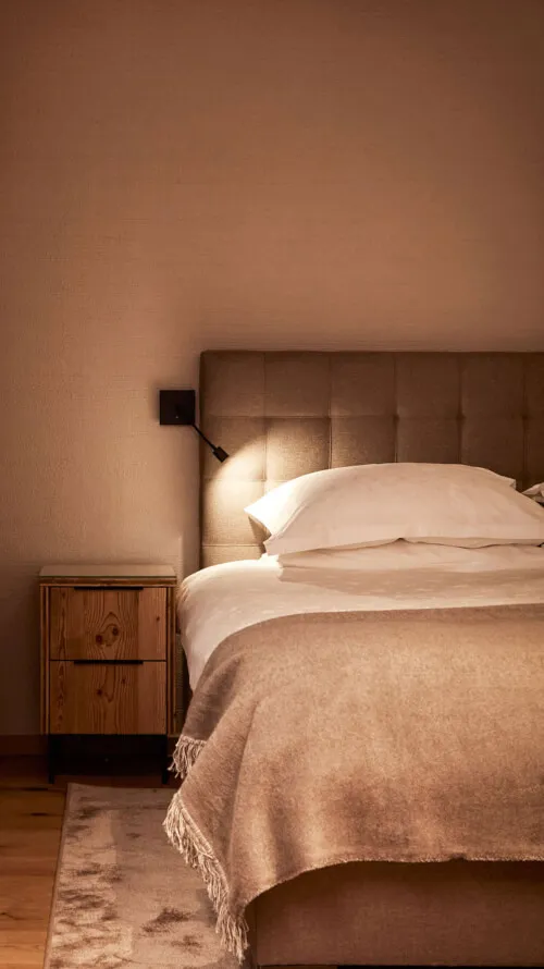 Gemütlich eingerichtetes Zimmer mit Bett und Nachttischlampe im Promontoria Hochgurgl GmbH - TOP Hotel Hochgurgl, perfekt für Wellness und Entspannung