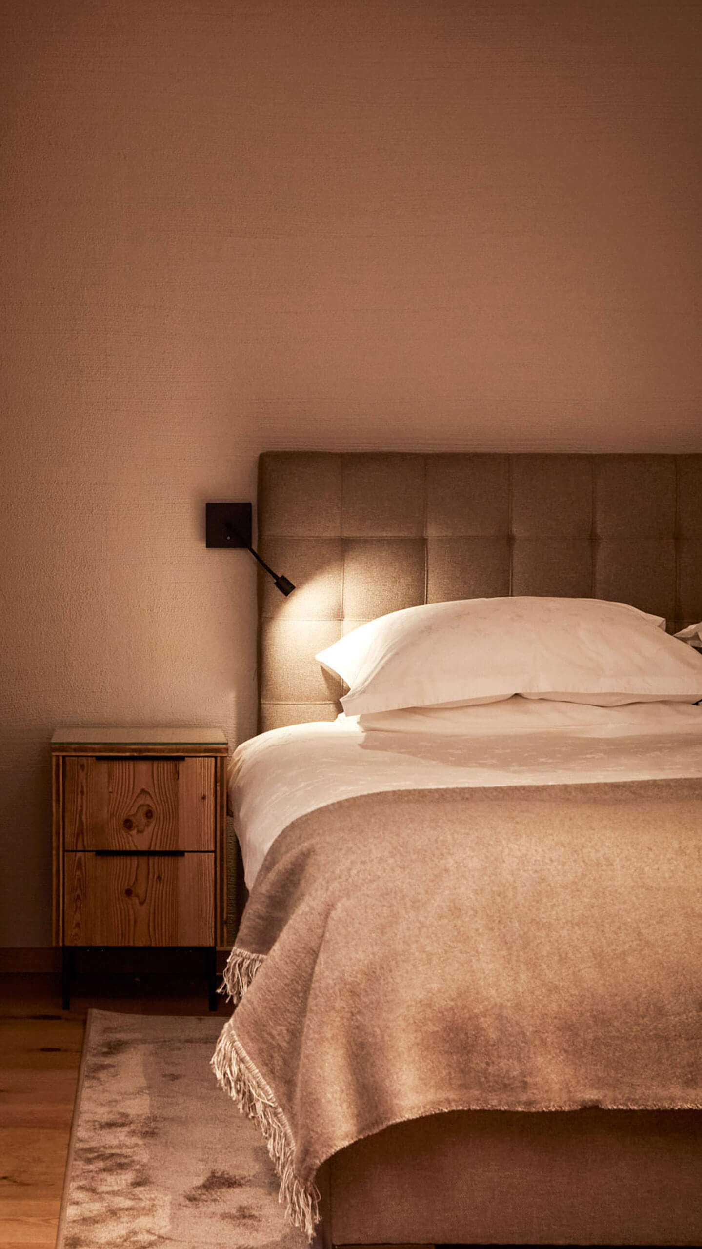 A comfortable bed with a lamp on the side in a hotel room owned by Promontoria Hochgurgl GmbH - TOP 
