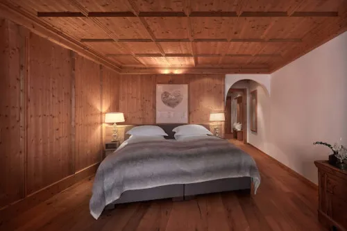 Schlafzimmer mit holzvertäfelten Wänden und einem Bett