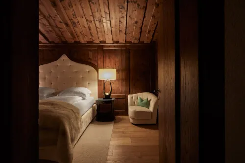 Ein gemütliches Schlafzimmer mit einem Bett und einem Stuhl im TOP Hotel Hochgurgl