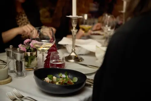 Elegantes Essen im TOP Hotel Hochgurgl mit Gourmet-Salat, Kerzenlicht und feinem Wein.