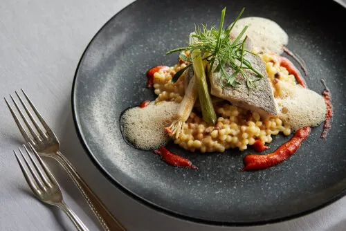 Elegantes Fischgericht mit Couscous serviert im TOP Hotel Hochgurgl, ideal für Gourmet-Essen.