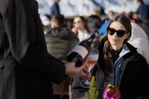 Junge Frau genießt Cocktails im TOP Hotel Hochgurgl, einer Luxusunterkunft in den Alpen.