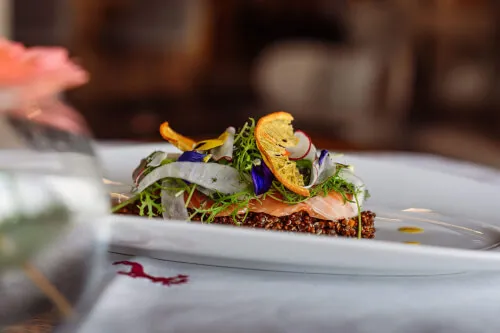 Gourmetgericht mit Lachs und essbaren Blumen im TOP Hotel Hochgurgl.