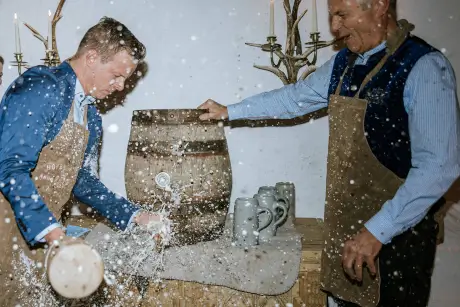 Two men celebrate at TOP Hotel Hochgurgl with beer barrels and mugs during the opening party.