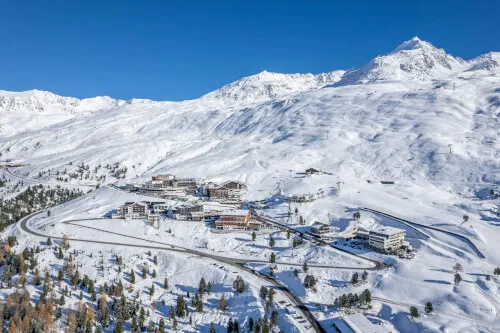 Ein Panoramablick auf das TOP Hotel Hochgurgl zwischen verschneiten Bergen in Österreich.