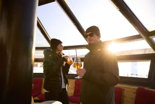 Gäste im TOP Hotel Hochgurgl genießen Getränke mit atemberaubendem Ausblick bei Sonnenuntergang.