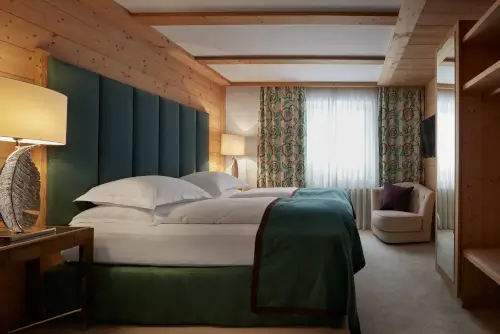 Luxuriöses Hotelzimmer mit modernem Design, einschließlich großem Bett und stilvoller Lampe.