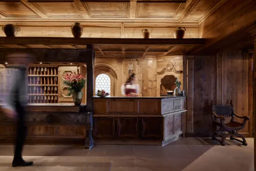 Empfangen im Holzinterieur des TOP Hotels Hochgurgl mit Blumen und Gästen.