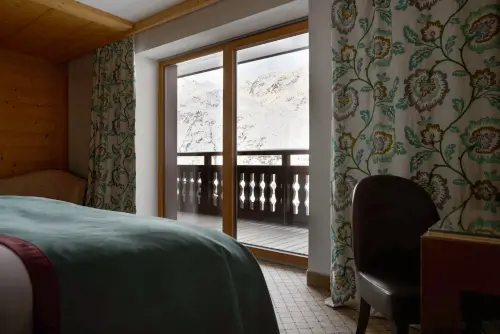 Gemütliches Hotelzimmer im TOP Hotel Hochgurgl mit Blick auf schneebedeckte Berge.