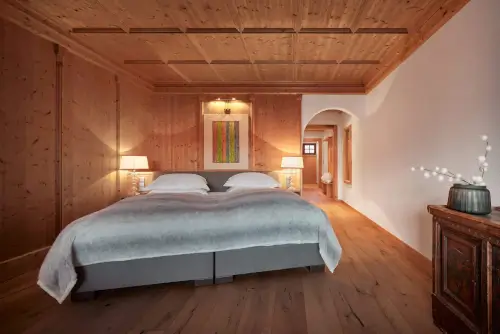 Gemütliches Hotelzimmer mit Doppelbett, Lampe und buntem Kunstwerk im TOP Hotel Hochgurgl, Tirol.