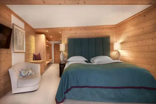 Luxuriöses Hotelzimmer im TOP Hotel Hochgurgl mit Doppelbett und elegantem Holzmobiliar.