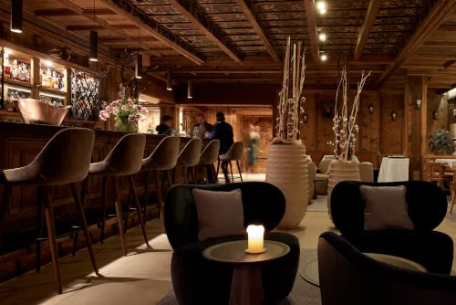 Stilvoller Barbereich mit Tischen und Stühlen im TOP Hotel Hochgurgl, ideal für gute Gespräche und Drinks
