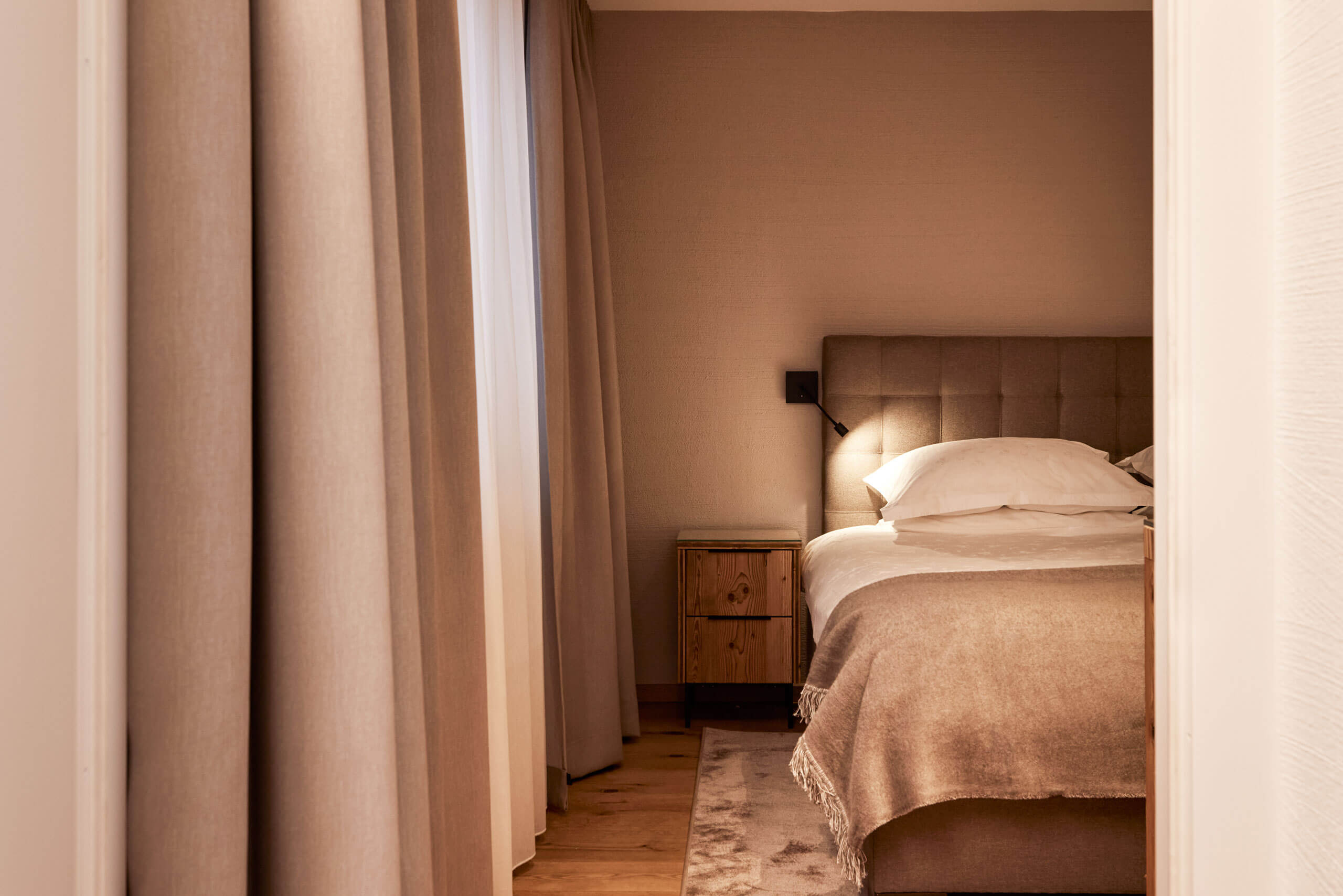 Ein Bett mit einem Licht an der Seite in der Prinzensuite im TOP Hotel Hochgurgl, einer alpinen Suit