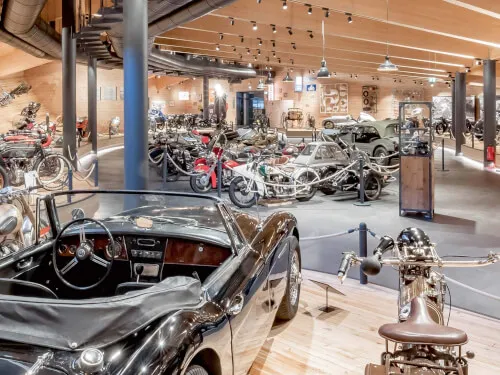 Ausstellung im Top Mountain Motorcycle Museum mit klassischen Autos und Motorrädern.