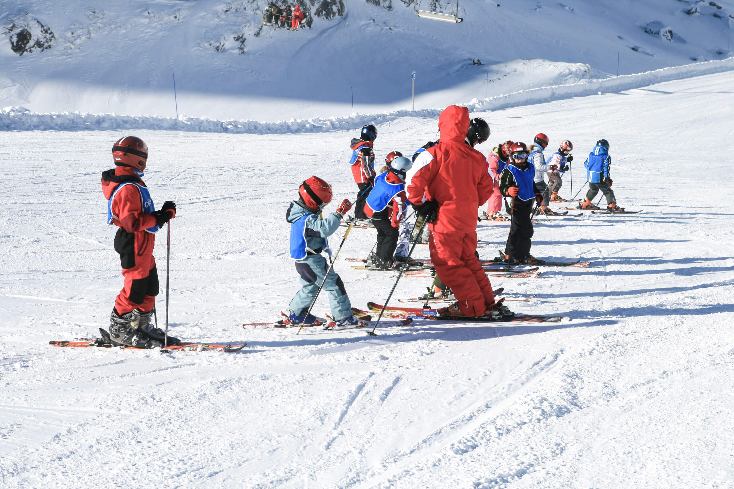 A group of people skiing on the snow in Skischule Erste Schritte auf den Brettern. Children and adul