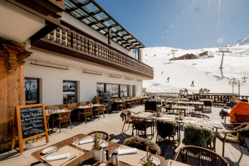 Sun terrace at TOP Hotel Hochgurgl with snowy mountain view, winter furniture setup