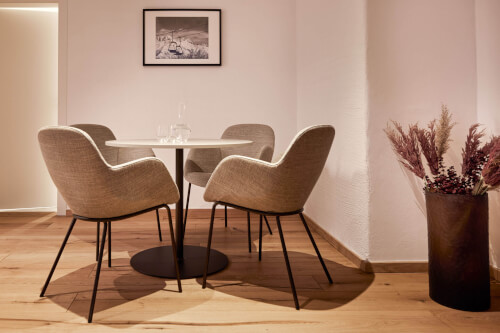 Ein Raum mit einem Esstisch, Stühlen und einer Pflanze