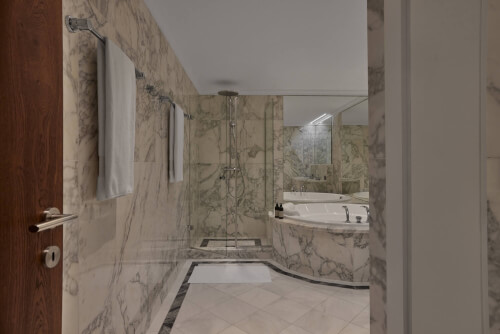 Ein Badezimmer mit Marmorwänden und einer Badewanne im TOP Hotel Hochgurgl