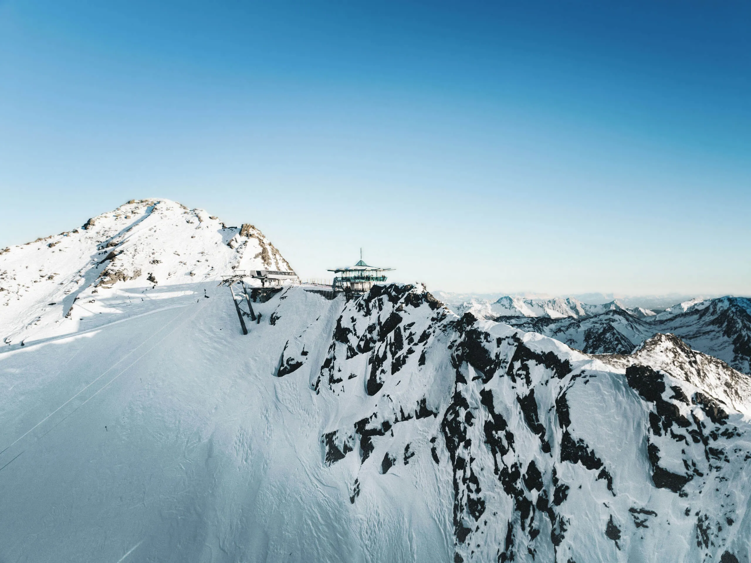 Blick auf das Skigebiet Obergurgl-Hochgurgl mit schneebedeckten Bergen und einem Skilift.