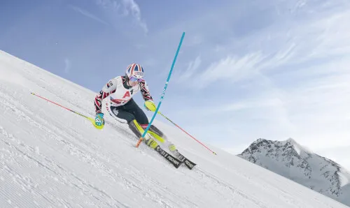 Eine Person fährt auf Skiern einen Berg hinunter im Schnee