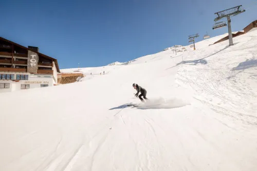 Ein Skifahrer, der elegant die Pisten in der Nähe des TOP Hotel Hochgurgl hinunterfährt.