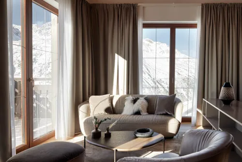 Gemütliches Wohnzimmer des TOP Hotels Hochgurgl mit Blick auf die verschneiten Berge.