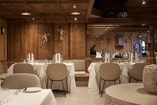 Eleganter Speiseraum im TOP Hotel Hochgurgl mit dekorierten Tischen und gemütlichem Holzinterieur.