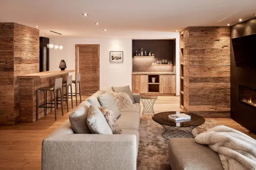 A cozy living room with a couch and a bar, possibly from TOP Hotel Hochgurgl