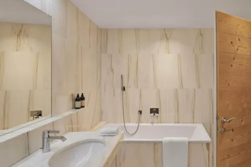 Ein Badezimmer mit Badewanne und Spiegel in einem Hotel in Hochgurgl