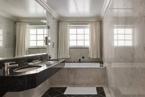 Luxurious bathroom with marble countertop and bathtub at TOP Hotel Hochgurgl