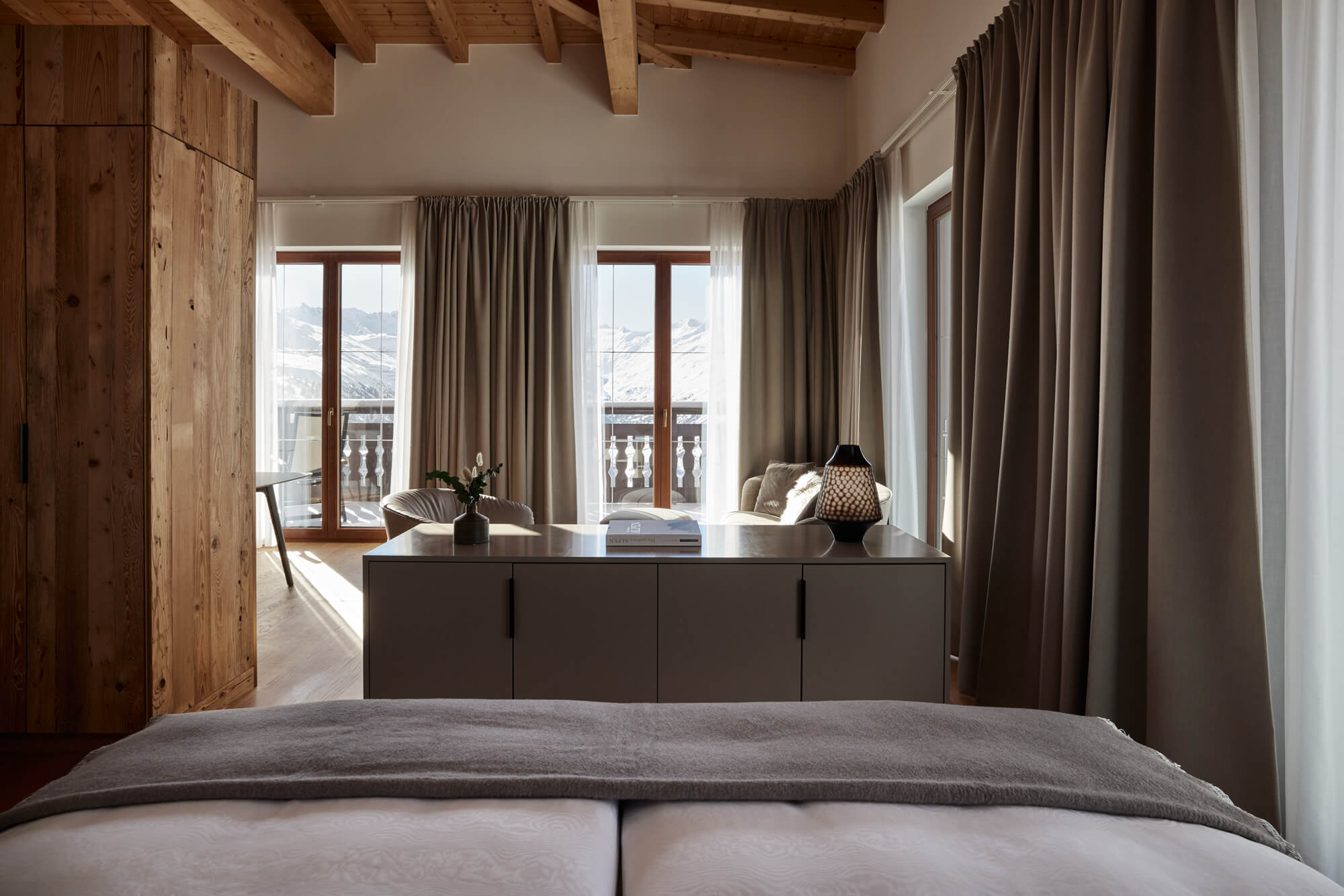 A room with a large table and chairs and a large window in the Herzogsuite Mountain view at TOP Hote